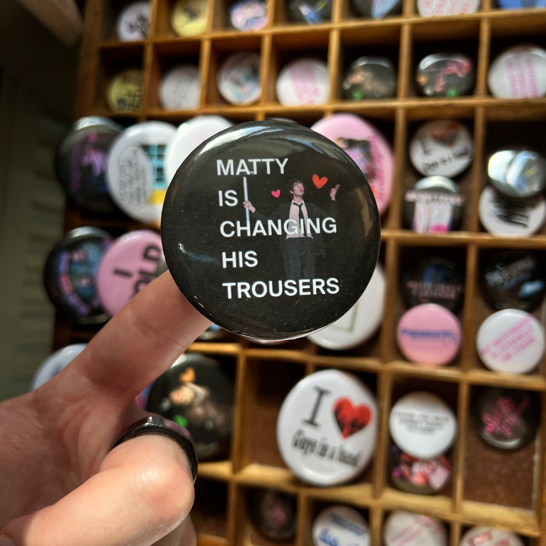 Matty is changing his trousers button badge