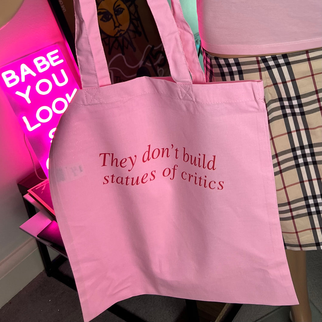 they don't build statues of critics tote bag