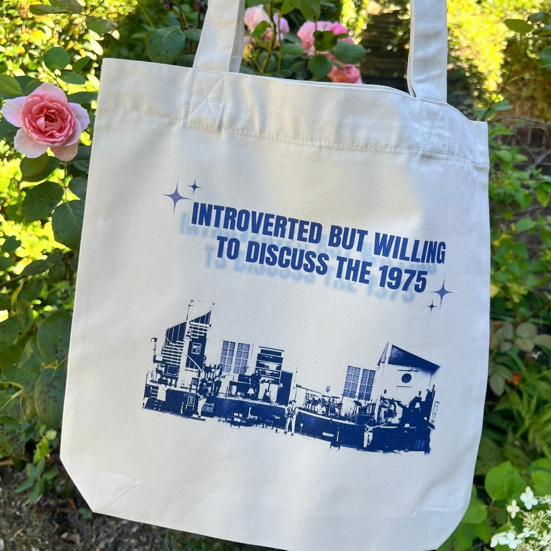 introverted but willing to discuss the 1975- print woven tote bag